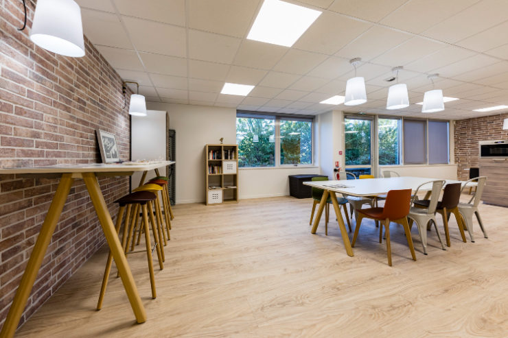 un espace cafétéria avec une grande table et des chaises