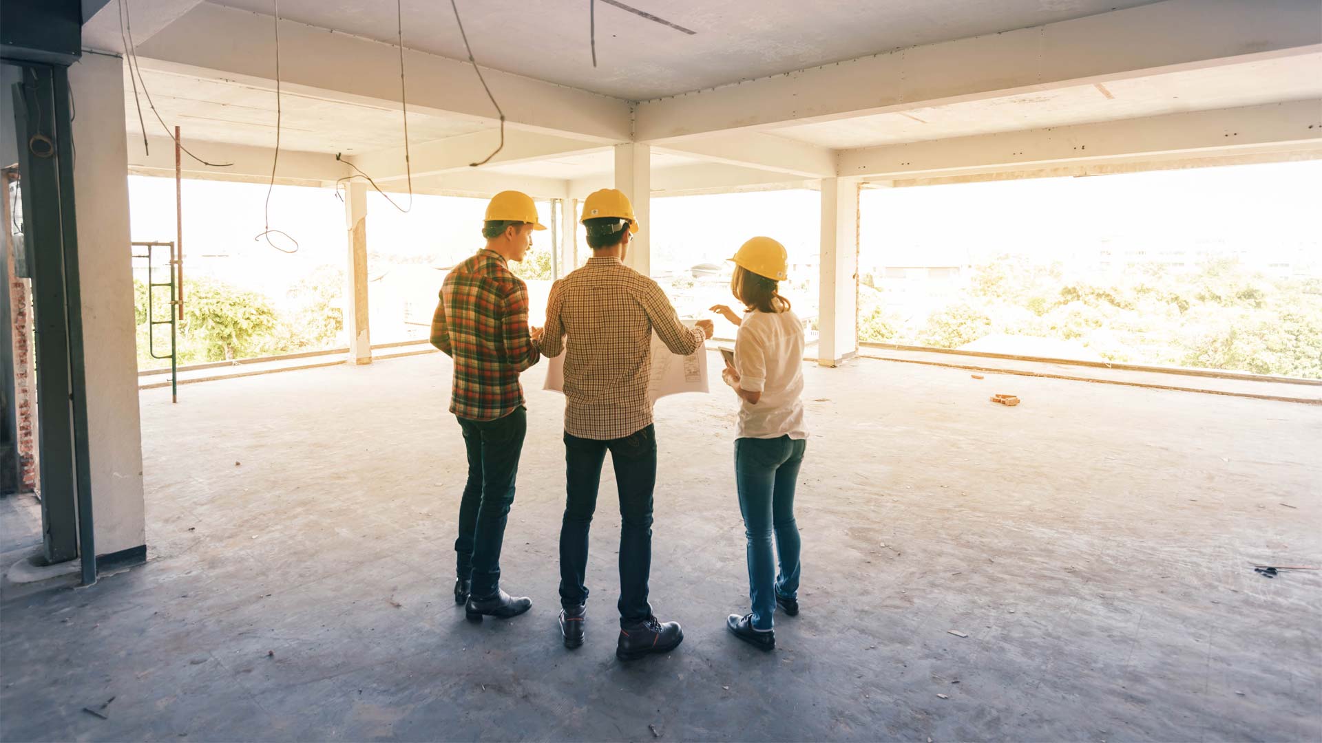des personnes avec des casques de chantier dans un bâtiment en construction