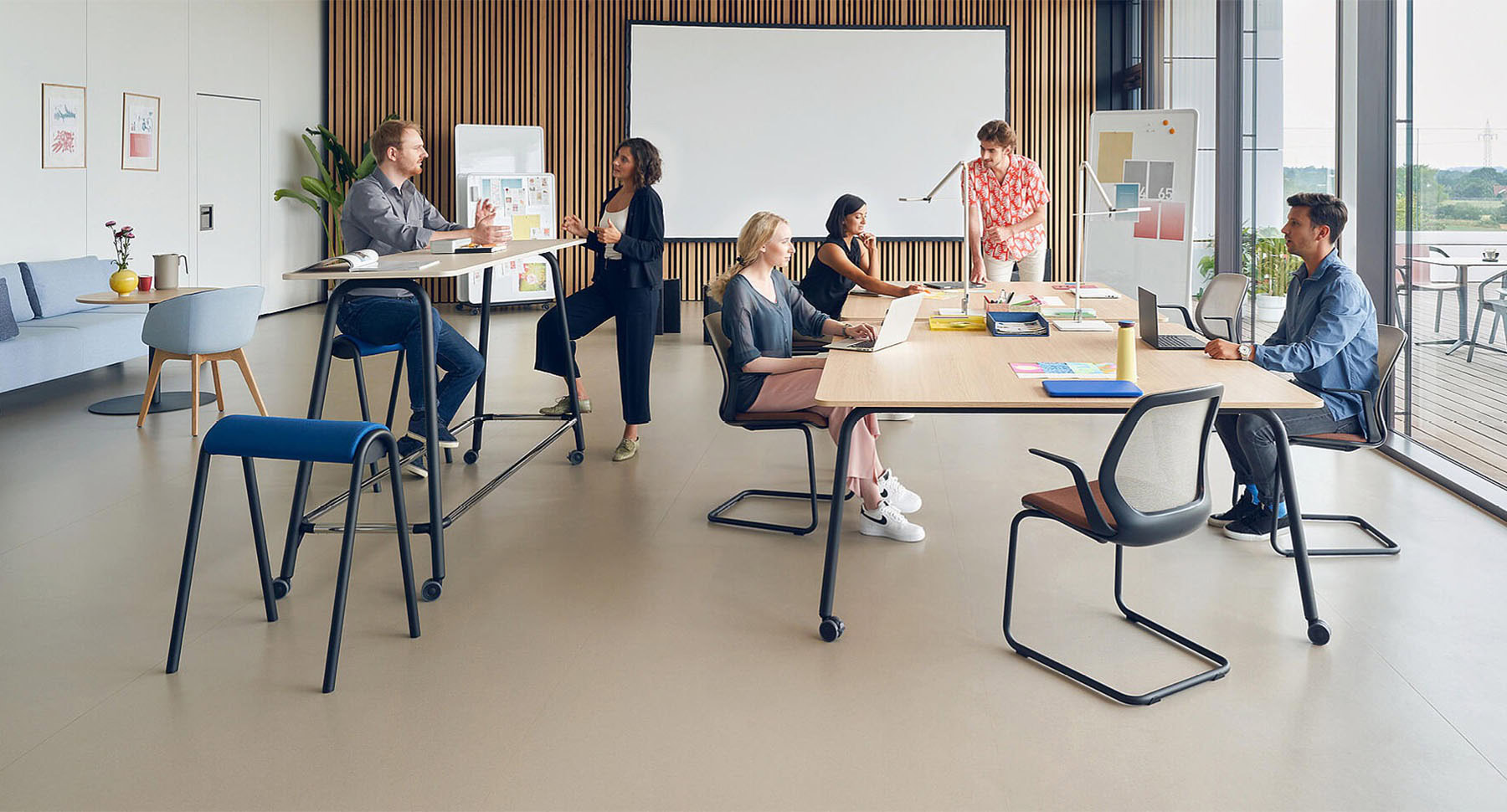 un espace de travail ouvert avec du mobilier de bureau flexible et agile et des personnes qui échangent