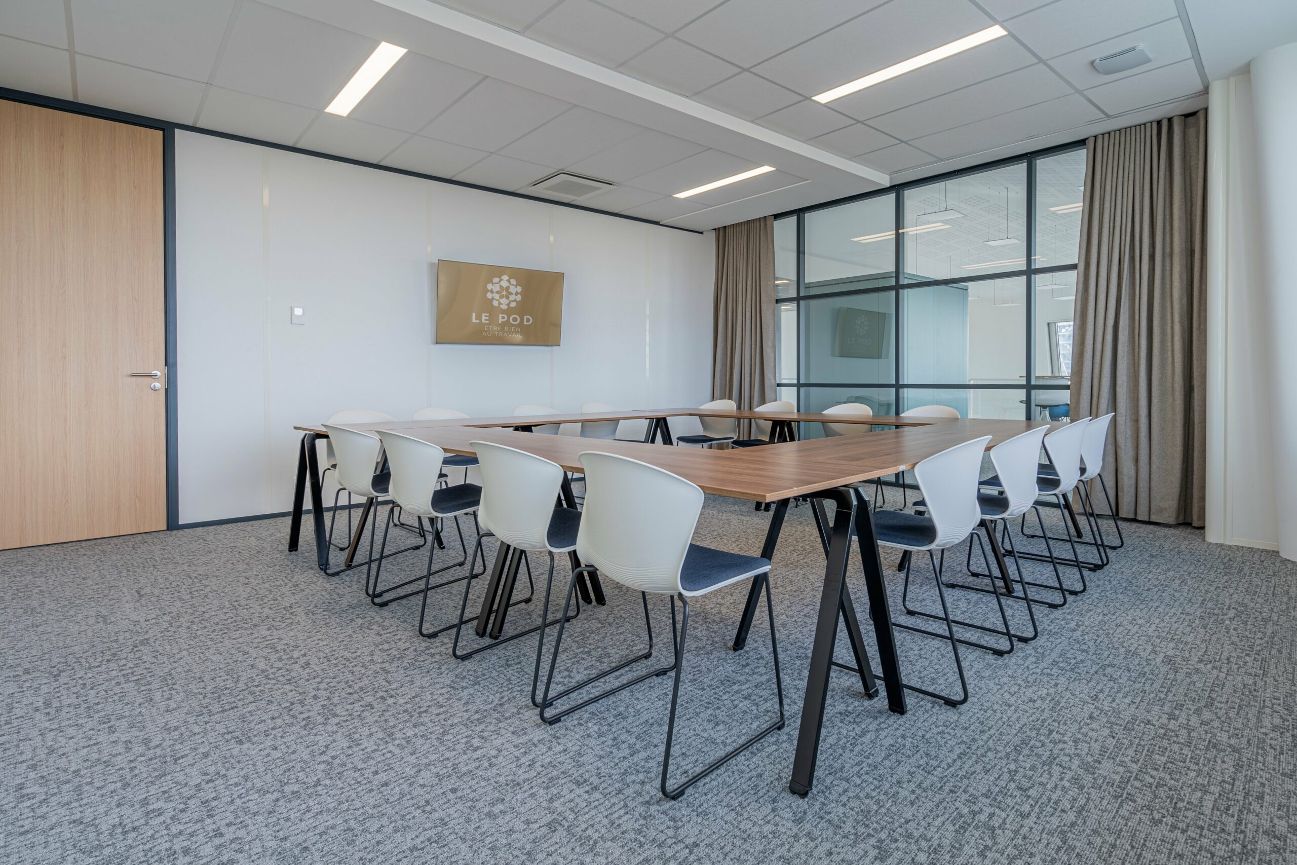 une salle de réunion avec un table et des sièges blancs