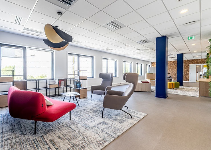 Un espace bureau ouvert avec un tapis et des sièges lounge