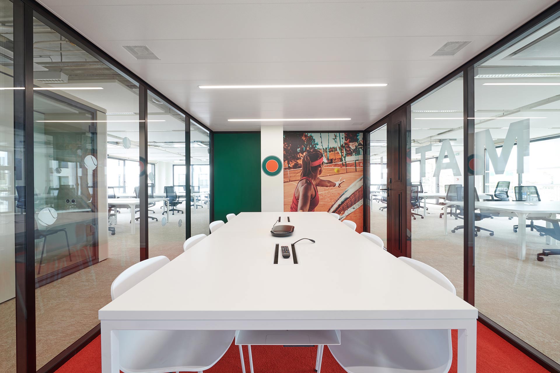 une bulle -salle de réunion avec une grande table et des sièges et un papier peint représentant un terrain de tennis