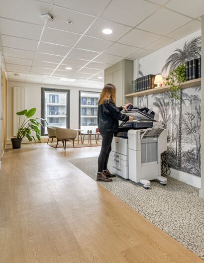 un espace de circulation avec photocopieuse, un mur avec papier peint