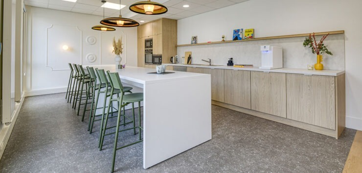 un espace cuisine avec un ilot central et des chaises hautes