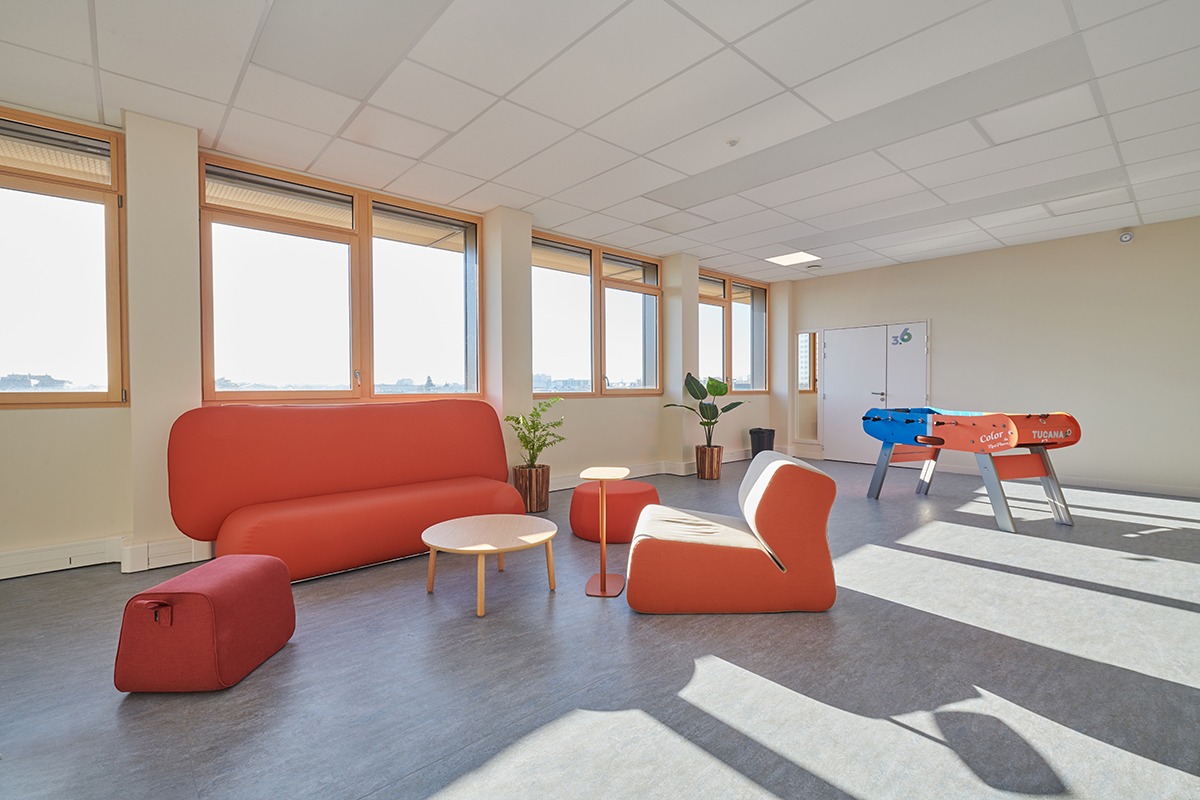 Un espace détente étudiant avec une banquette orange et un babyfoot