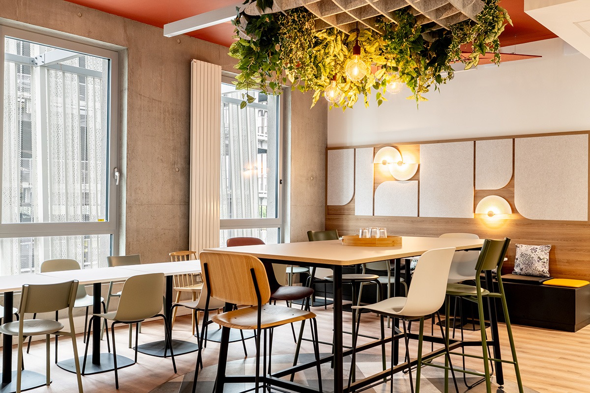 un espace caféteria avec une suspension acoustique des tables  hautes et des sieges