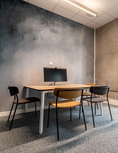 un espace reunion avec une table des sieges de travail et un écran de pc