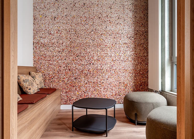 un espace détente avec des poufs et une table basse, en fond une tapisserie murale