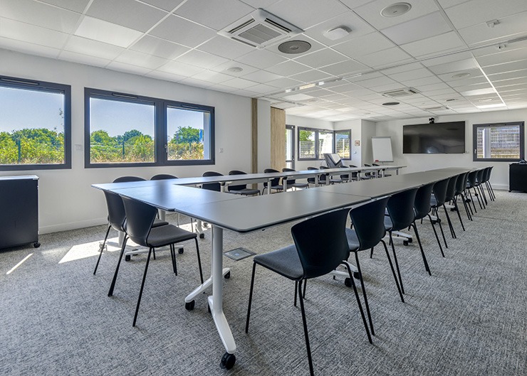 un vaste espace de réunion avec une grande table et des sièges