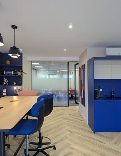 une table haute avec des tabourets hautes et un meuble de cuisine bleu