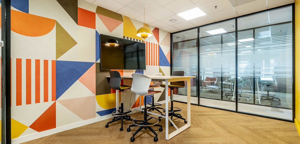 un espace collaboratif avec un table et des sièges de travail en hauteur