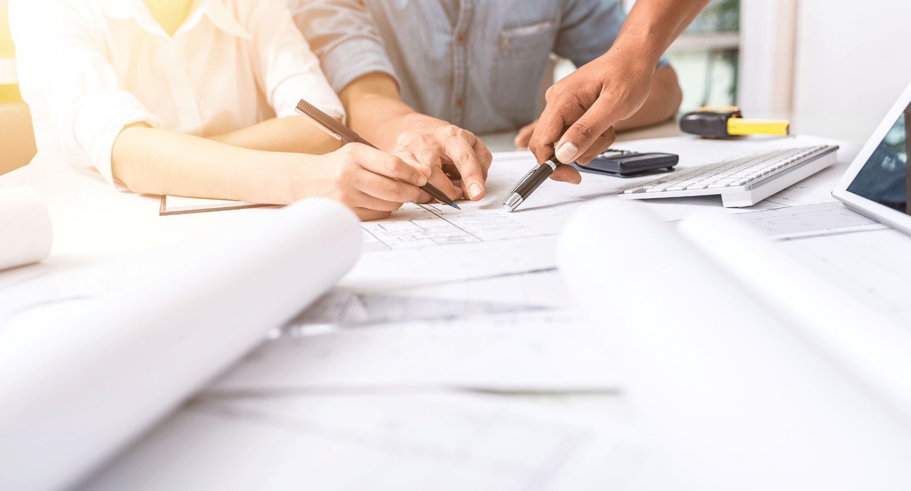 un plan de conception, des mains qui pointent sur ce plan