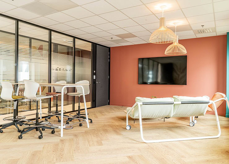 un espace collaboratif avec des canapés, une table, des sièges hauts