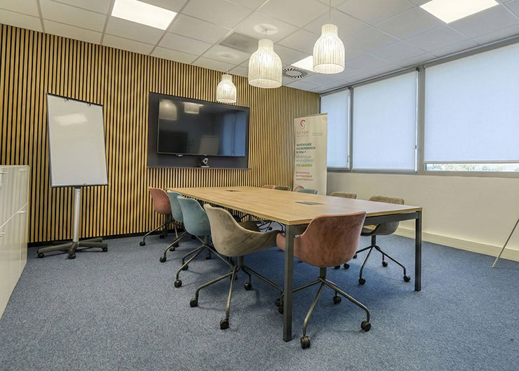 un espace collaboration avec une grande table et des sièges de travail