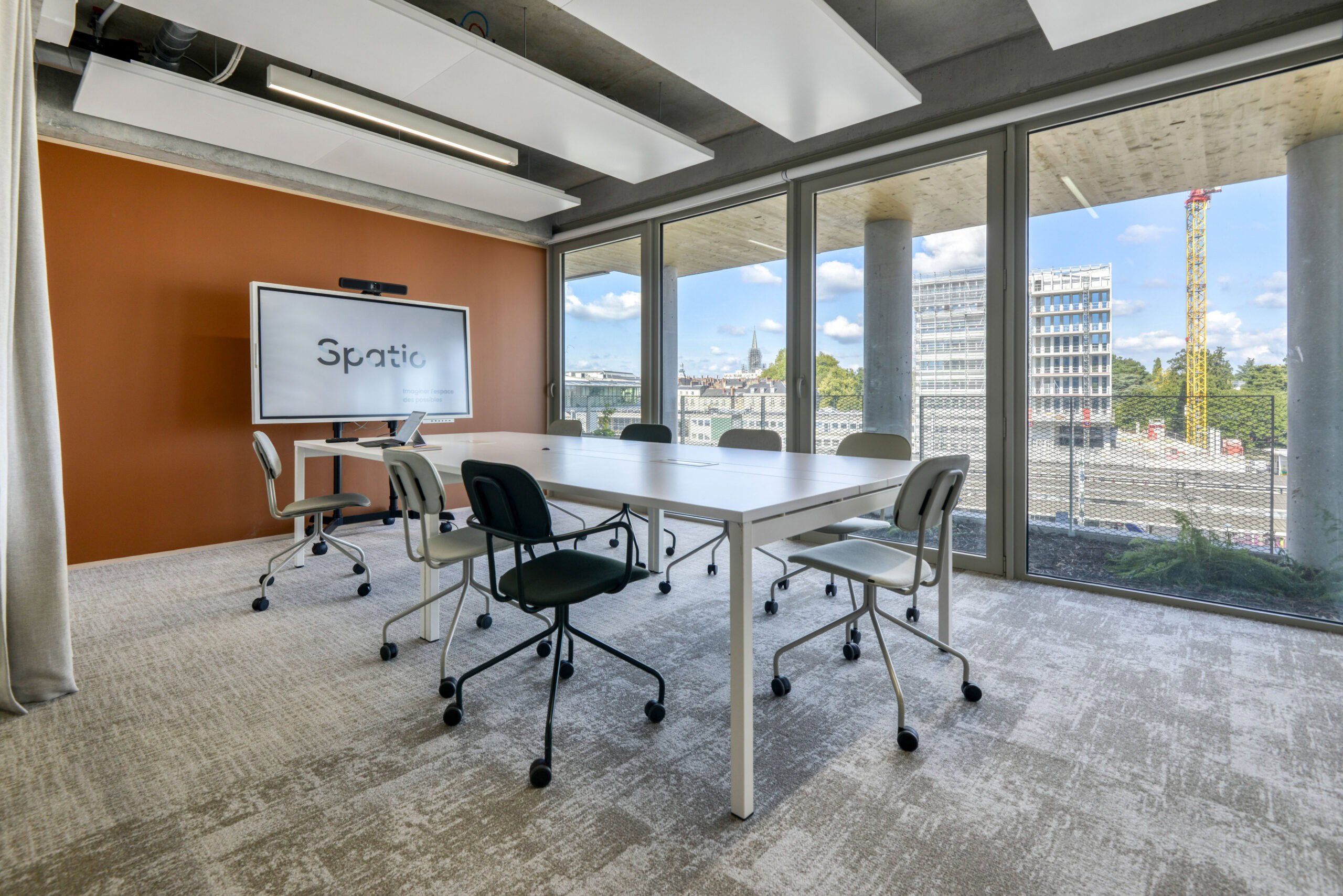 une salle de réunion avec du mobilier de bureau, table de réunion et sièges de travail