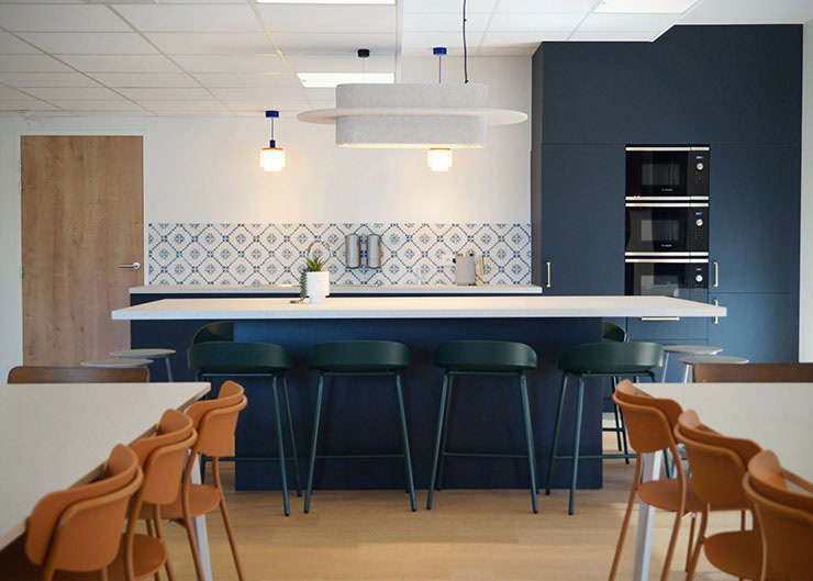 Un espace cuisine avec un ilot central et des tabourets hauts
