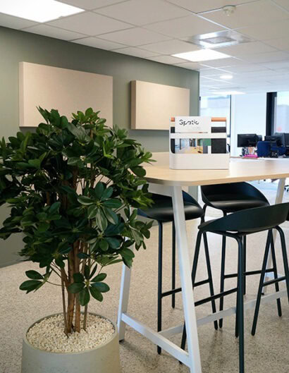 un espace de travail ouvert avec une table haute et des tabourets hauts
